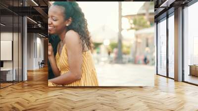 portrait of happy man and smiling woman watching video on smartphone. Close-up of joyful young interracial couple browsing photos on mobile phone on urban city background Wall mural