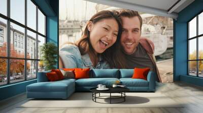 Romantic couple sits on the pier on the yacht background and take a selfie Wall mural