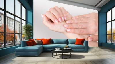 Closeup top view horizontal photography of elegant pastel pink natural manicure. Female hands isolated on white background. Wall mural