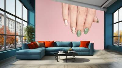 Closeup top view of beautiful hand of white woman isolated on pink pastel background. Fingernails with stylish trendy two colors faded manicure made with modern gel polish and silver stamping design. Wall mural