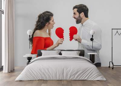 Portrait of an Excessive Couple. Conducting two parts of the heart paper. Isolated on a white background. Wall mural