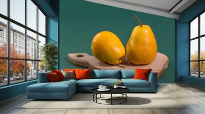 Ripe juicy yellow pears on a green background Wall mural