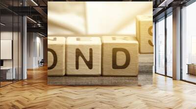 Businessman puts wooden blocks with the word Bonds. A bond is a security that indicates that the investor has provided a loan to the issuer. Equivalent loan. Unsecured and secured bonds. Wall mural