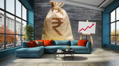 Indian rupee INR symbol money bag and red trend arrow up chart. Deposit and savings. Increasing profits and revenues, capital growth, profitable business efficiency. Economic prosperity welfare rise Wall mural