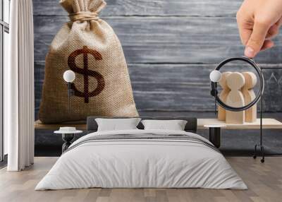 Magnifying glass is looking at the people and a money bag with a dollar sign on the scales. attracting investment, business cooperation, crowdfunding and startup. the cost of specialists and workers Wall mural