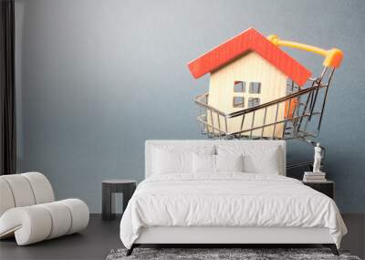 Wooden house in a Supermarket trolley. The concept of buying a house or apartment. Affordable housing. Profitable and cheap loans for real estate. Buying a home. Mortgage and loan. Place for text Wall mural