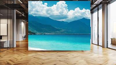 A beautiful beach with a clear blue ocean and mountains in the background Wall mural