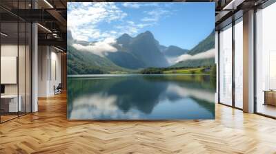 A beautiful mountain lake with a cloudy sky in the background. The lake is surrounded by mountains and trees, creating a serene and peaceful atmosphere Wall mural