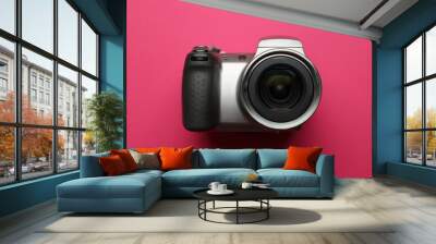 A camera with a black lens and a black grip. The camera is on a pink background Wall mural