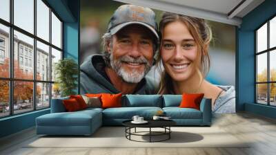 A fit active father embraces his adult daughter in a lush park, radiating love and joy. Wall mural