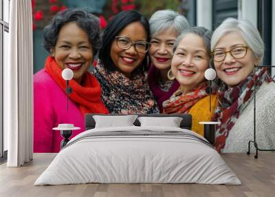 A group of women are smiling and posing for a photo. They are all wearing scarves and glasses Wall mural