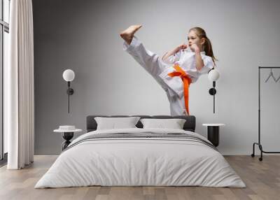 A strong kick, a girl in a kimono on a white background. Wall mural