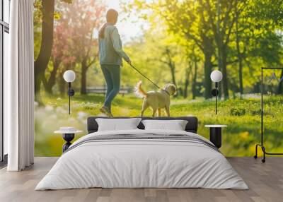 A woman with her playful puppy enjoy a sunny stroll through a blooming garden park. Wall mural