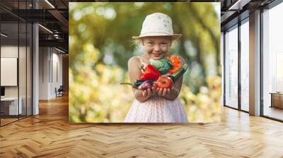 Cute girl holding vegetables from the garden, fresh rural products in hands. Wall mural