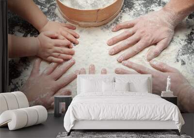 Family cooking homemade cakes, mom's hands and two daughters in flour on a black table background. Wall mural