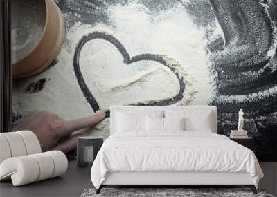 Heart and symbol of love, painted on flour, with a woman's hand. Wall mural