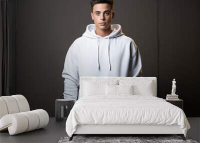 Stylish young Caucasian male model in a white hoodie, exuding confidence. Blank background for design template. Wall mural