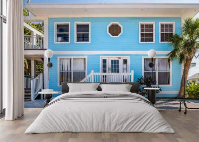 Colorful single family blue turquoise teal and white bungalow home house by beach with palm trees in South Florida Wall mural