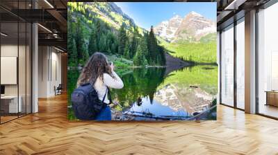 Maroon Bells in Aspen, Colorado in July 2019 summer and mirror reflection at sunrise with woman photographer back taking picture photo Wall mural