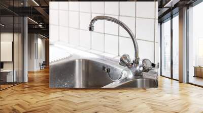 Old stainless steel faucet and kitchen room double sink closeup with two dials and tile backsplash in home or apartment Wall mural