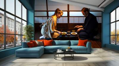 Young couple seiza sitting on floor pillows with Japanese ryokan kaiseki dishes, eating soba noodles, natto, edamame and soy sauce on table by sliding paper doors Wall mural