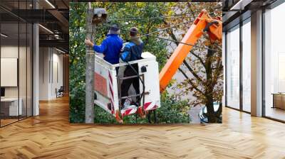 Electricians repair an electric pole after a storm. Wall mural