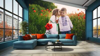 Children's love, a little boy and a girl, amicably spend time, laugh and smile, and kiss in the flowering field of poppies Wall mural