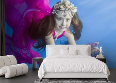 Ggirl in long, purple dresses wearing poses underwater  Wall mural