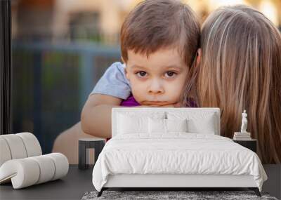 sad little boy on mother's shoulder Wall mural