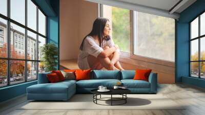 woman sitting on the window sill Wall mural