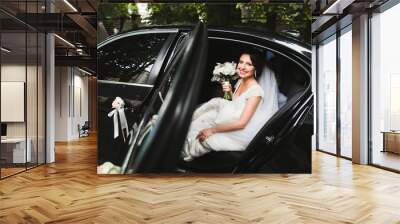 bride sitting in a stylish black foreign car Wall mural