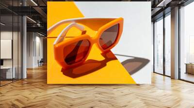 Minimal style composition made of trendy sunglasses closeup on orange and white sunlit background Wall mural