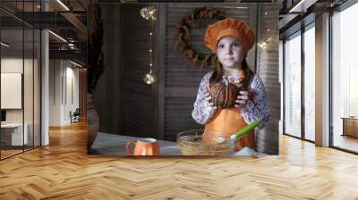 cute girl in a chef costume is cooking pumpkin pie in the kitchen. the process of making pumpkin pie for thanksgiving Wall mural