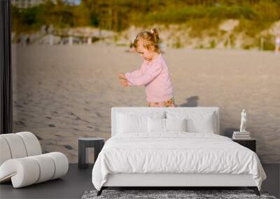 Adorable toddler girl on a sunny sand beach. Authentic childhood. Wall mural