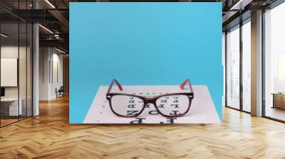 glasses lying on snellen test chart Wall mural