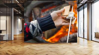 Closeup of Hands Building Smore with Roasted Marshmallow and Chocolate At Campfire Outdoors Wall mural