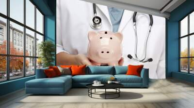 doctor with stethoscope holding piggy bank abstract Wall mural