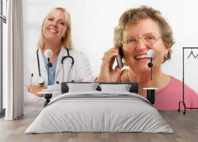 happy senior woman using cell phone with female doctor behind Wall mural