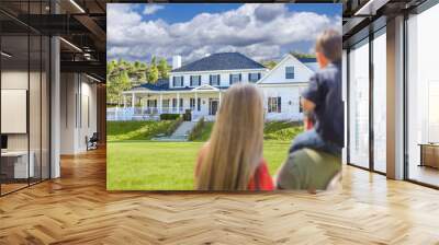 mixed race young family looking at beautiful home Wall mural