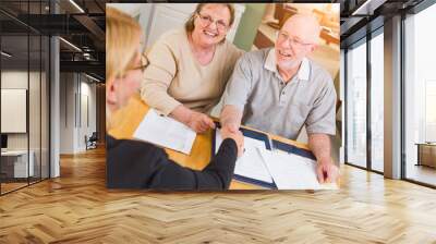 Senior Adult Couple Going Over Documents in Their Home with Agent At Signing Wall mural