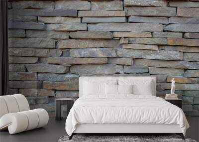 The wall is made of roughly hewn flat, thin stone granite tiles of gray, beige, and brown, laid out in horizontal rows of several levels. Structured mineral background for the design. Wall mural