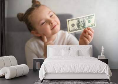 Cute little child girl with US Dollar bill as symbol of financial education. Selective focus. High quality photo Wall mural