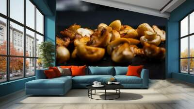 Fried golden mushrooms on a black background. Selected focus. Wall mural