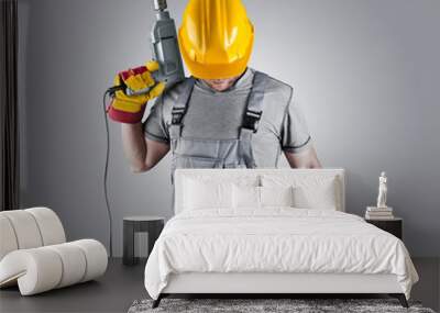 builder in a helmet with a hammer and a drill Wall mural