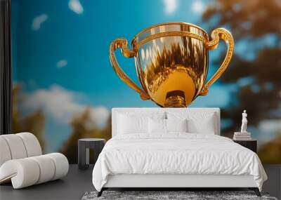 A golden trophy with a blurred background of blue sky and trees. Wall mural