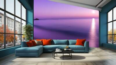 Serene Coastal Sunset with Rocks and Sun Reflection in Purple Hues Wall mural