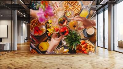 group of friends gathered around a table filled with brunch goodies like waffles, fruit, and mimosas Wall mural