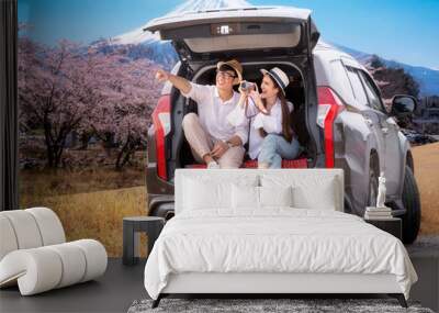 Asian couple travel Fuji mountain by suv car Wall mural