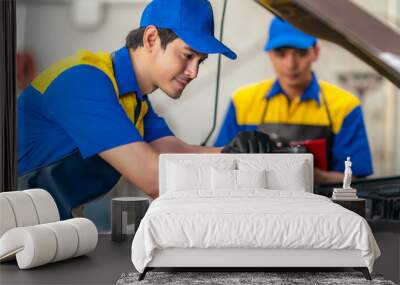 repairman and technician in car garage service in blue uniform Wall mural