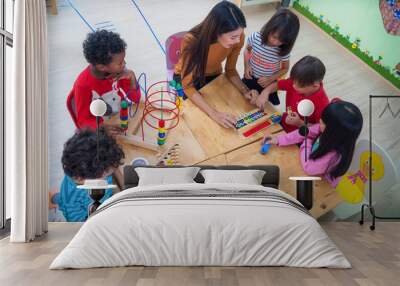 Teacher and student in an international preschool play a toy togather Wall mural